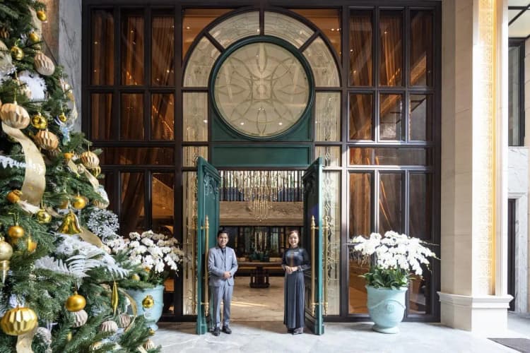 The impressive hotel entrance features festive decorations and a friendly staff welcoming guests.  